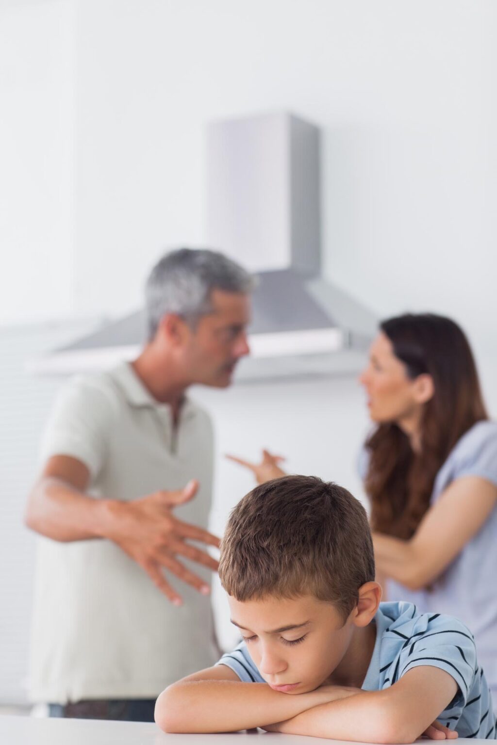 Junge traurig während Eltern im Hintergrund streiten